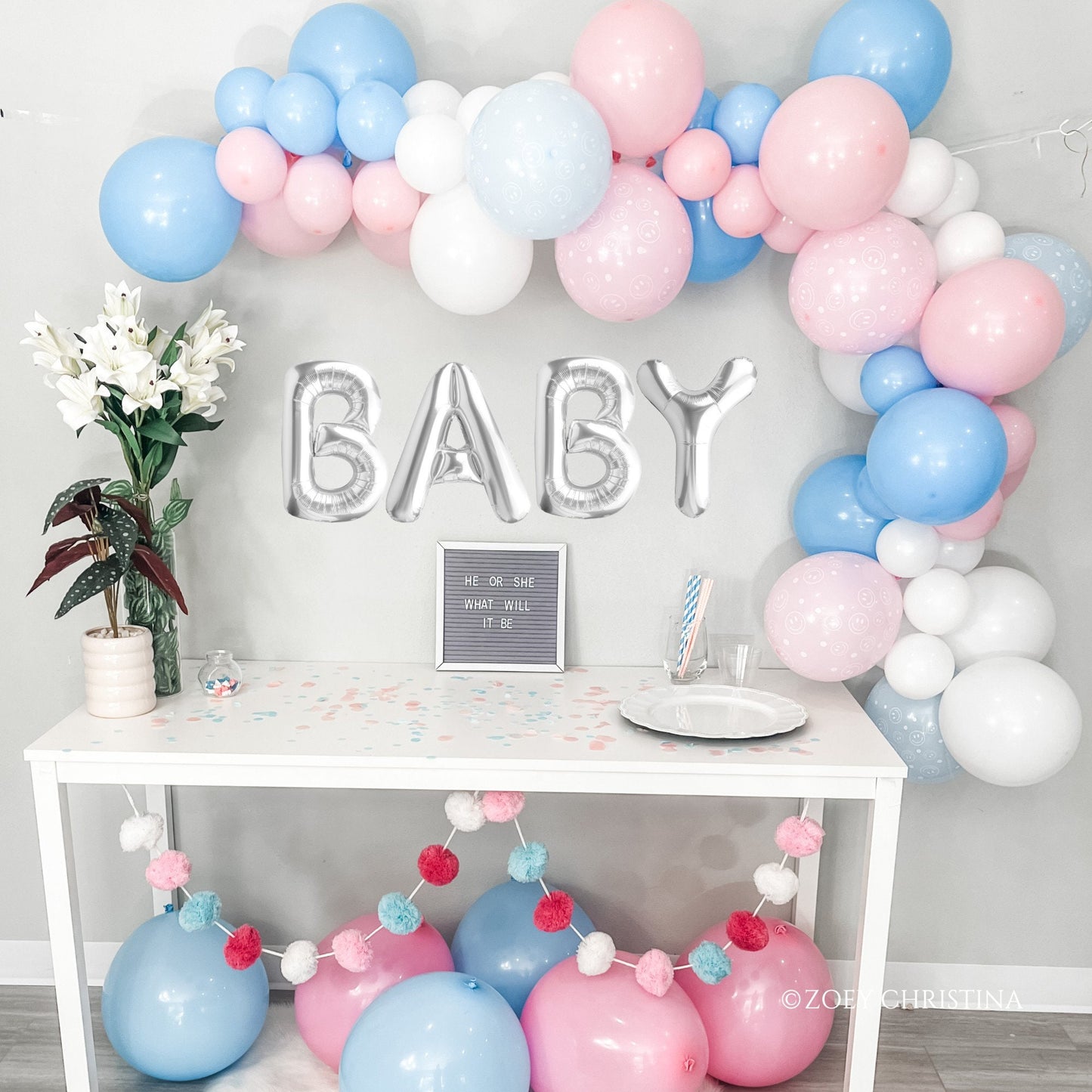 Gender reveal balloon garland party setup. Pink blue and white