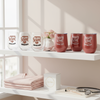 Set of 'Nursing School Survivor Glass' mugs on a shelf with decorative items.