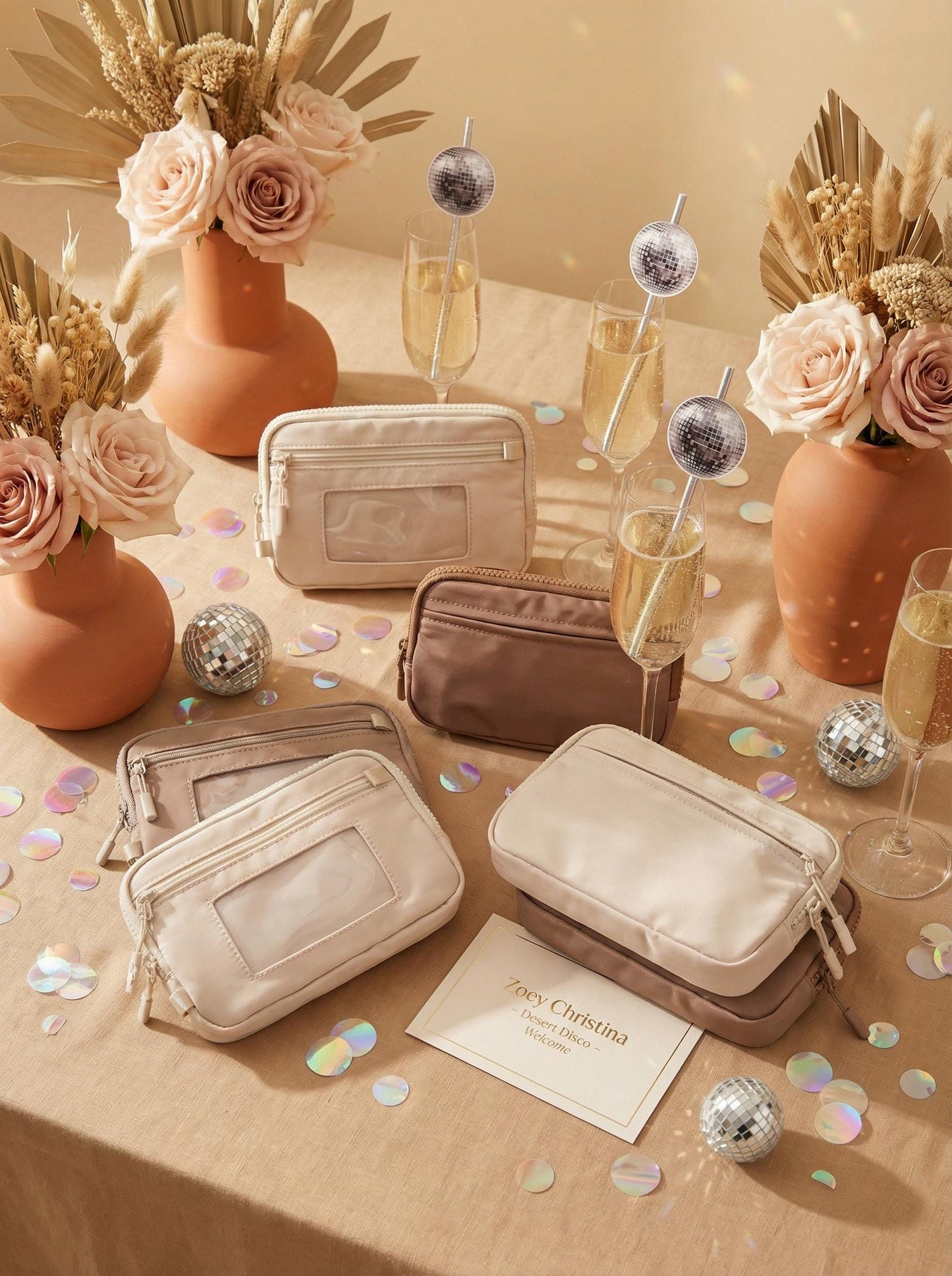 Beige makeup bags on a table with flowers, glasses, and confetti