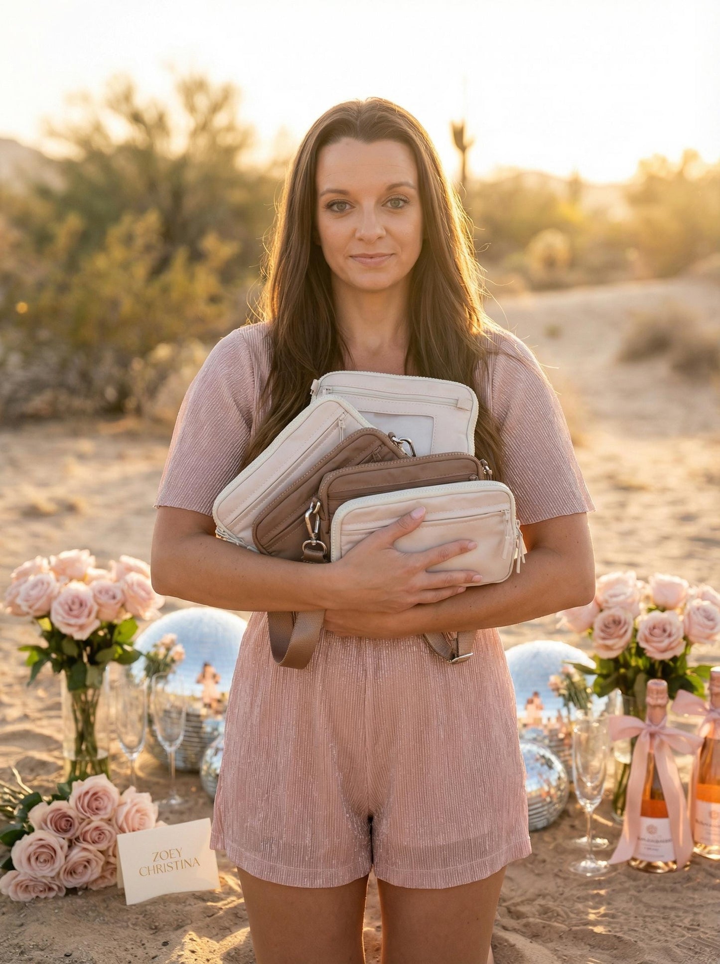 Woman holding multiple bags in a desert setting with floral arrangements and bottles.
